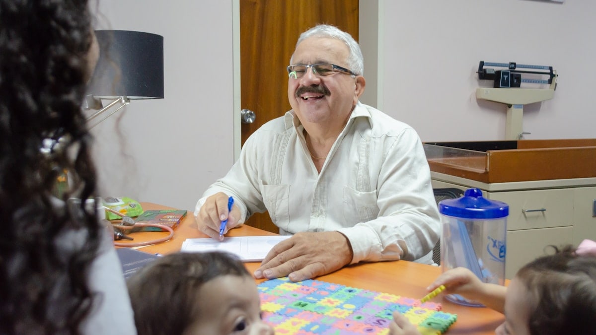 a man sitting at a table with a group of children